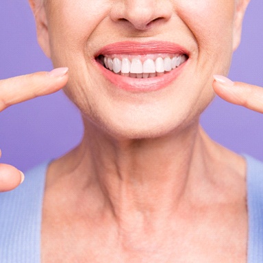 person pointing to their teeth