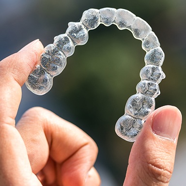 Hand holding a clear Clearcorrect Clear Aligners tray