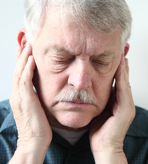 Older man holding his jaws in pain