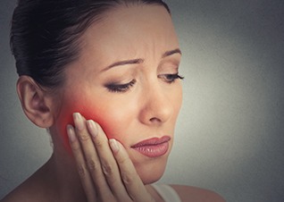 Woman in pain holding jaw