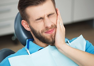 Man in pain holding jaw