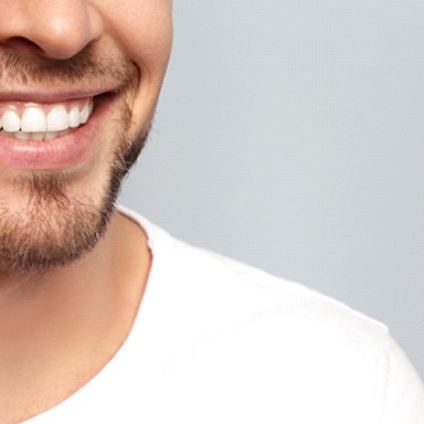 A man smiling in a white shirt