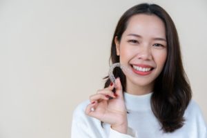 woman holding clear aligners near Marble Falls