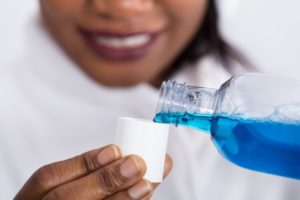Closeup of Marble Falls dentist measuring antimicrobial mouthwash in COVID-19